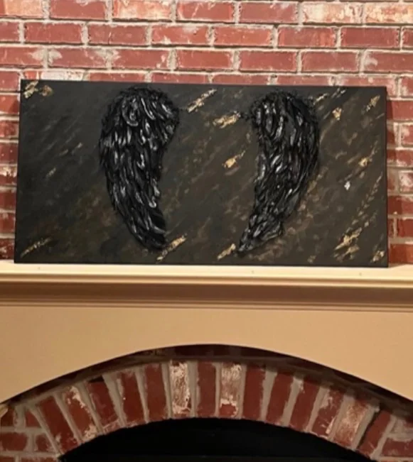 Wings for the Fallen — Mer Altom's inaugural assemblage piece, mixed-media memorial wings on a near-black ground